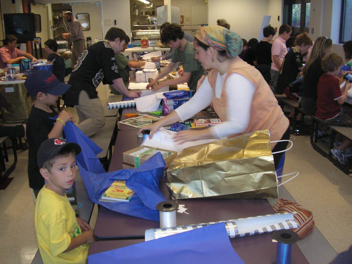 Busy room of people assembling gift packages