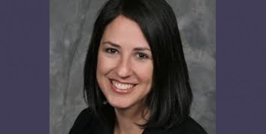 Headshot photo of a woman in a black top