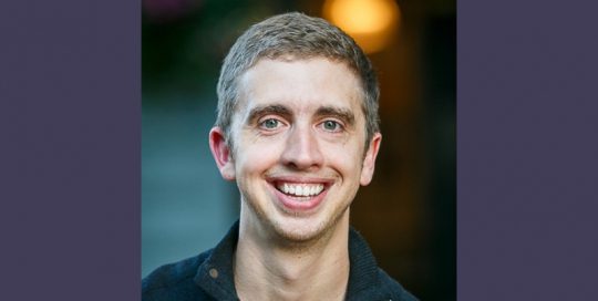 Headshot photo of a boy in a black shirt_