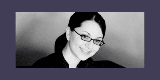Headshot photo of a woman in a black dress_Laura