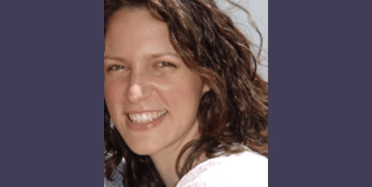 Headshot of a woman with curly short hair and smiling_ErinEllis