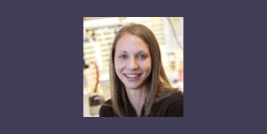 Headshot photo of a woman in a black top and smiling_Lauren Wiel