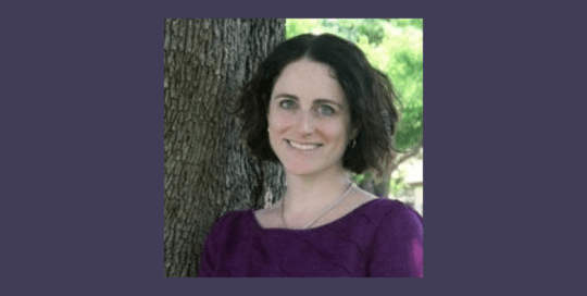 A woman in a purple top is standing near a tree_RachelLeventon